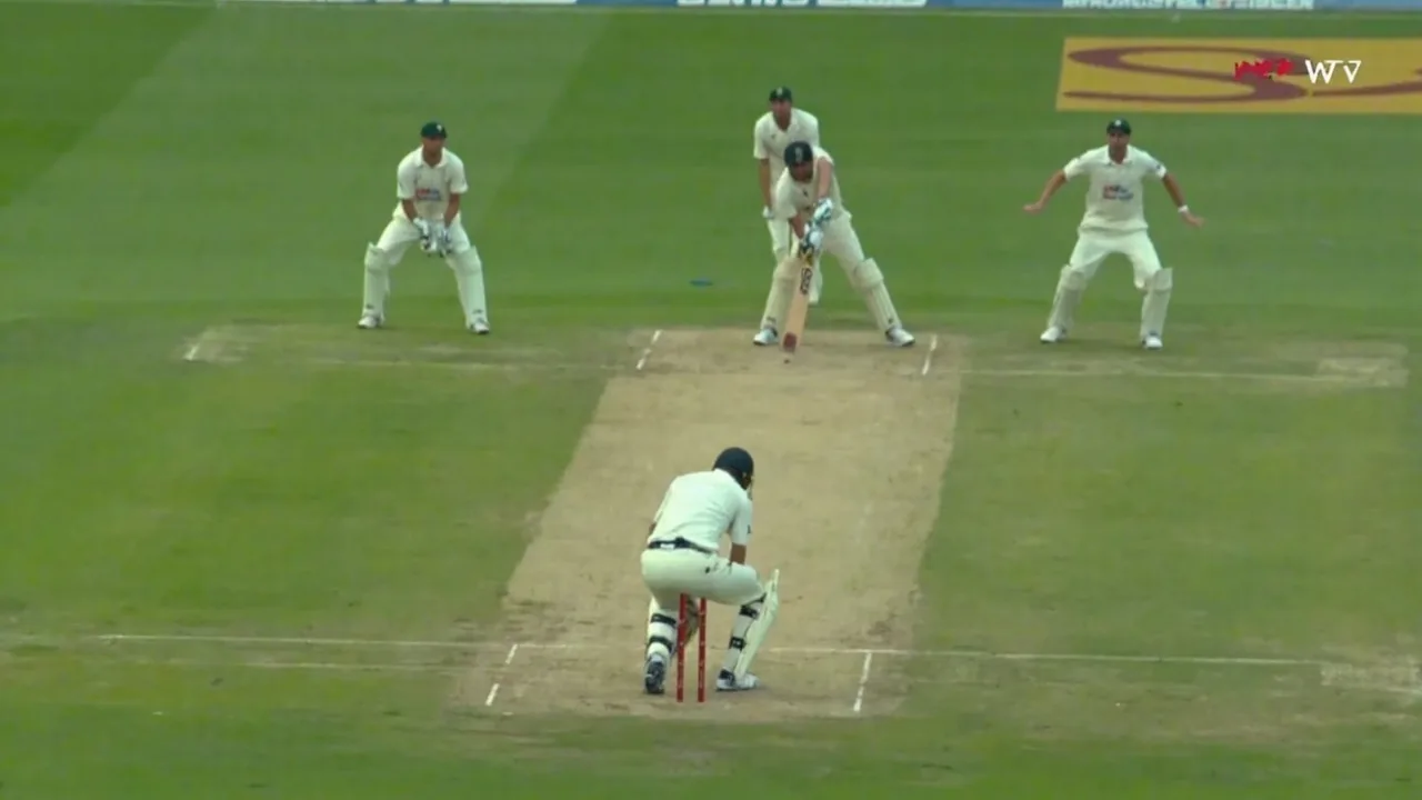 Medium tactical frame of a left-handed batter at the striker's end with fielders set on the off side and a green outfield beyond